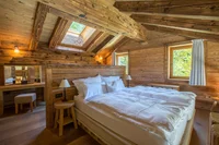 Spacious bedroom with a double bed, skylight, and wooden decor.