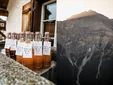 Bottles of local produce on a counter and a mountain view at sunset.