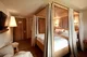 Cozy four-poster bed in a warmly lit hotel room in Switzerland.